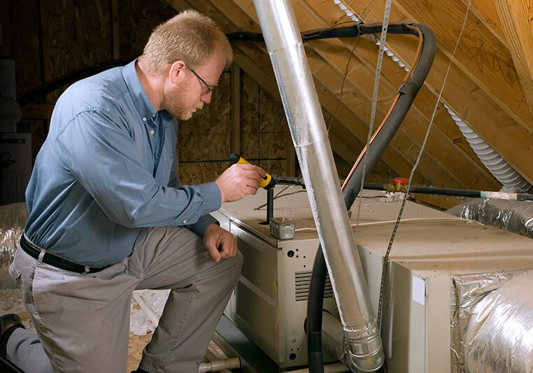 HVAC technician performing maintenance on a furnace.
